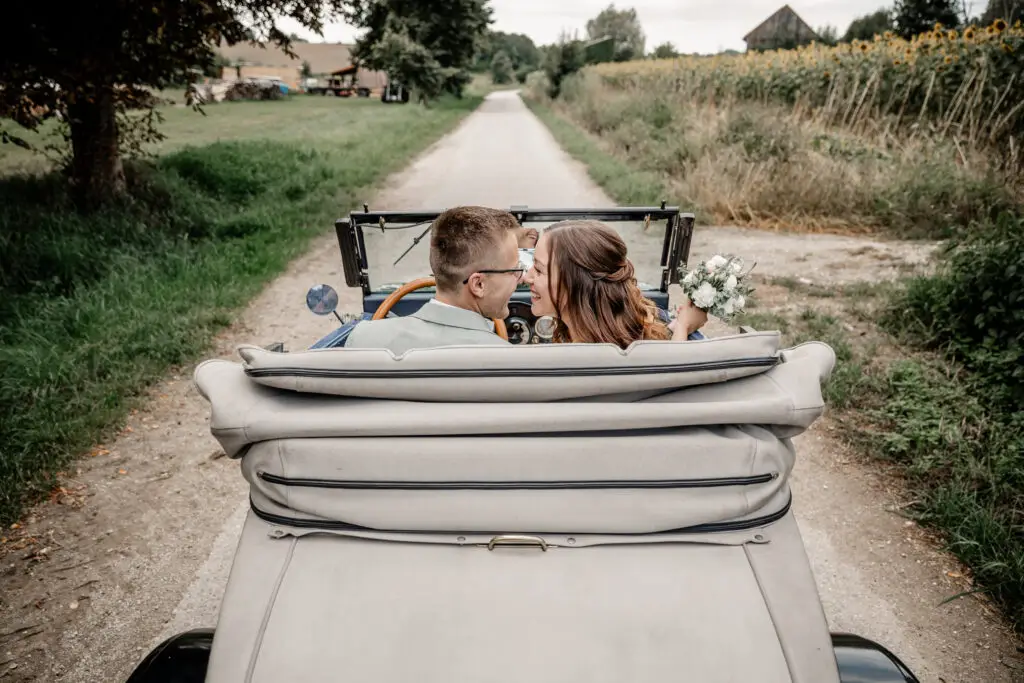 Elena & Thomas 1 Elena und Thomas im offenen Oldtimer in Wolnzach, ein inniger Moment während ihrer Hochzeitsreportage in der Hallertau.